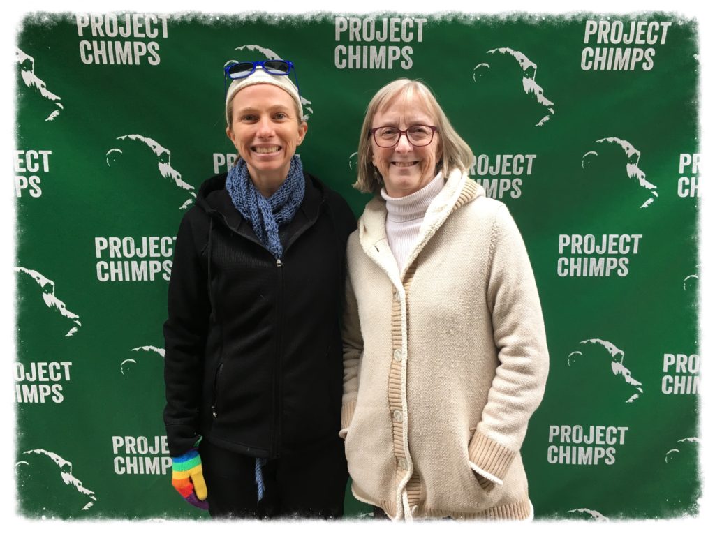 Megan and friend Suzanne standing in front of the Project Chimps banner.