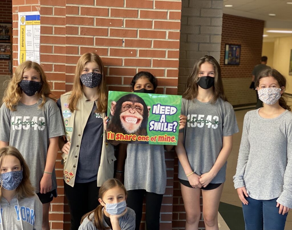 Girl scouts taking the poster off the wall!