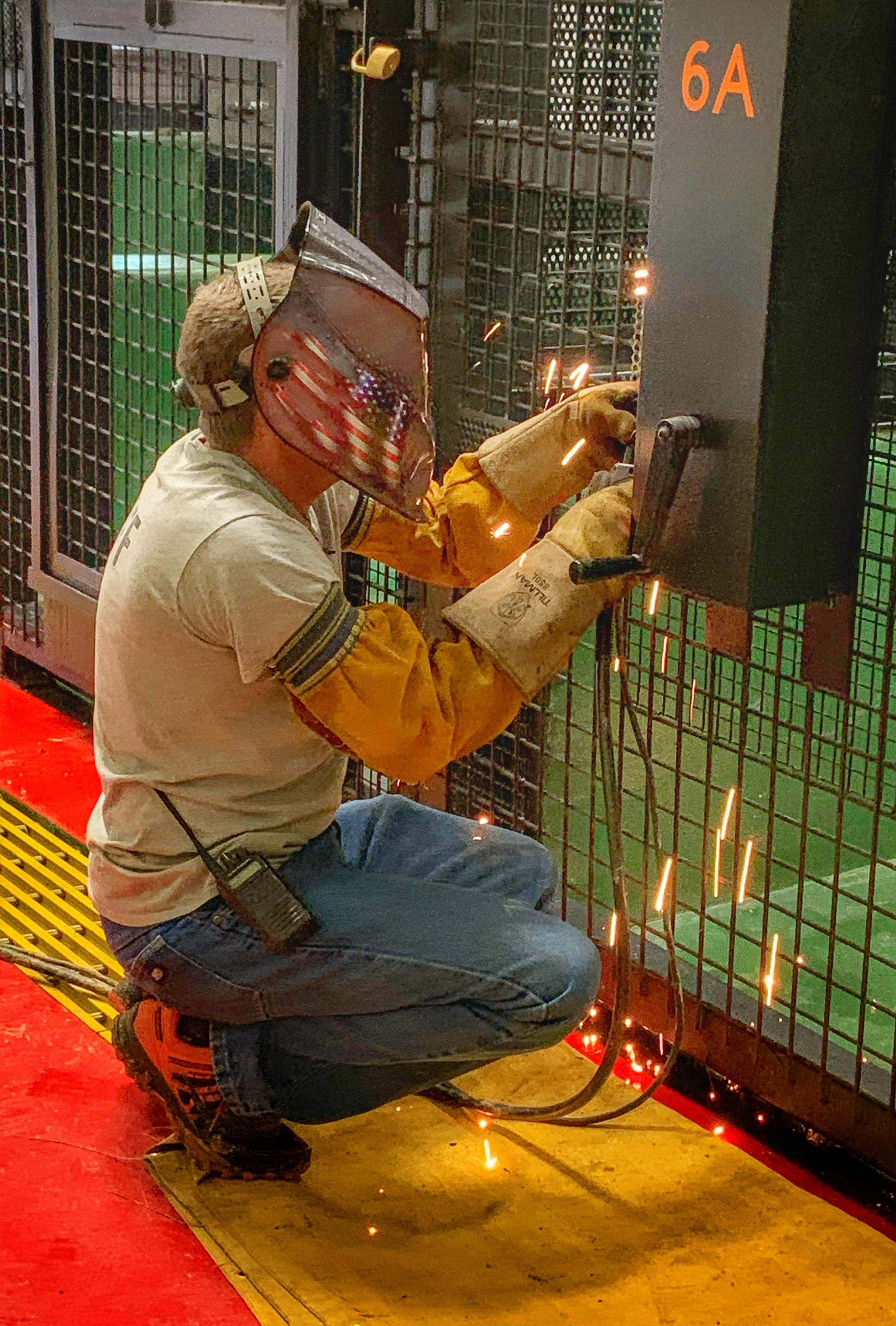 Volunteer Alan welding a chimp enclosure.